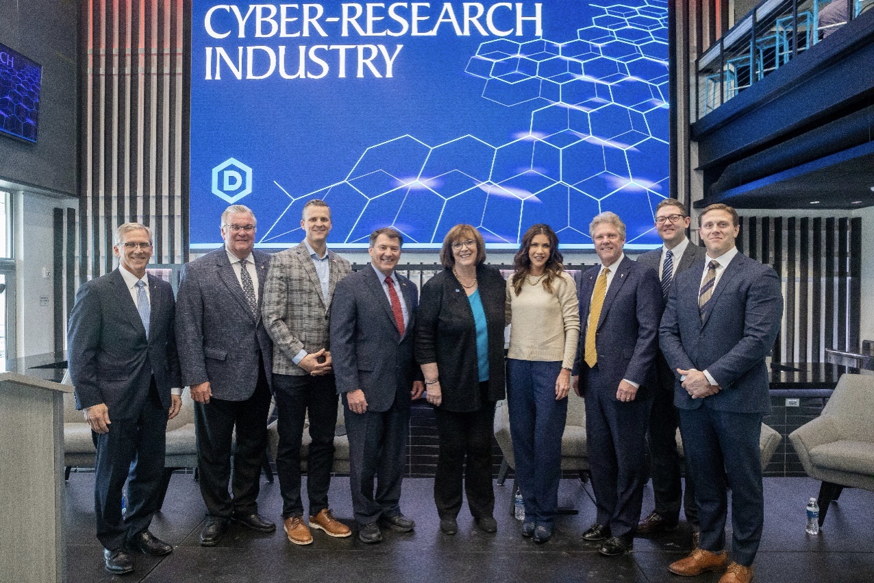a group of staff members standing in front of a Cyber-Research Industry sign